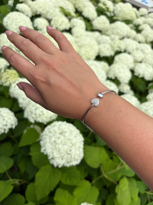 Zilveren hartvormige damesarmband – Heart to Handle design gedragen om pols, stijlvolle accessoire bij zomerse outfit.