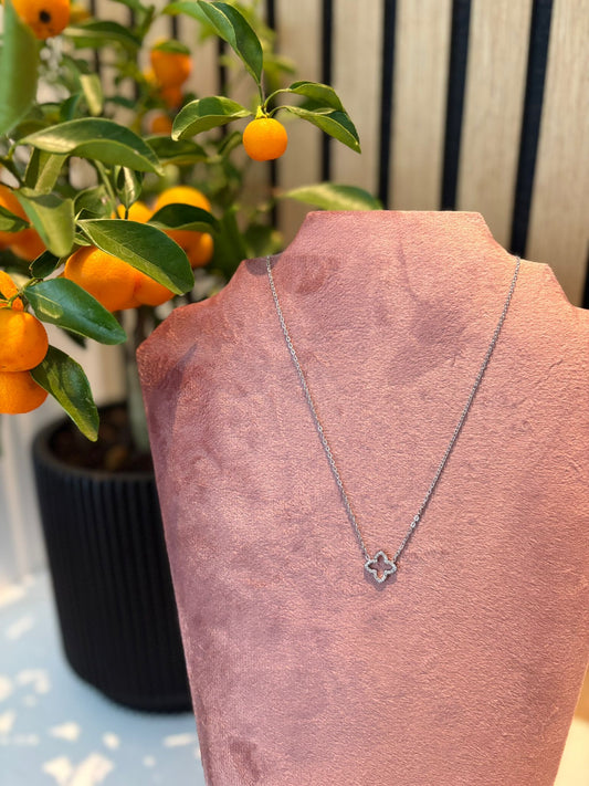 "Shine not sorry" ketting – Zilverkleurige schakelketting met klavervormige hanger op een roze fluwelen kettingdisplay